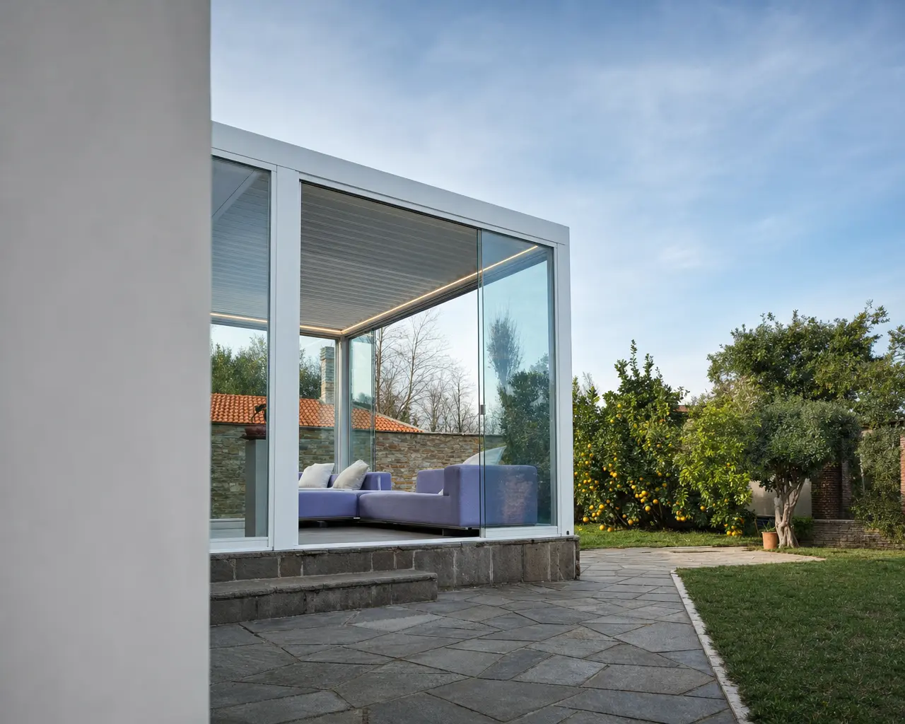 Veranda vetrata con salotto e vista sul giardino