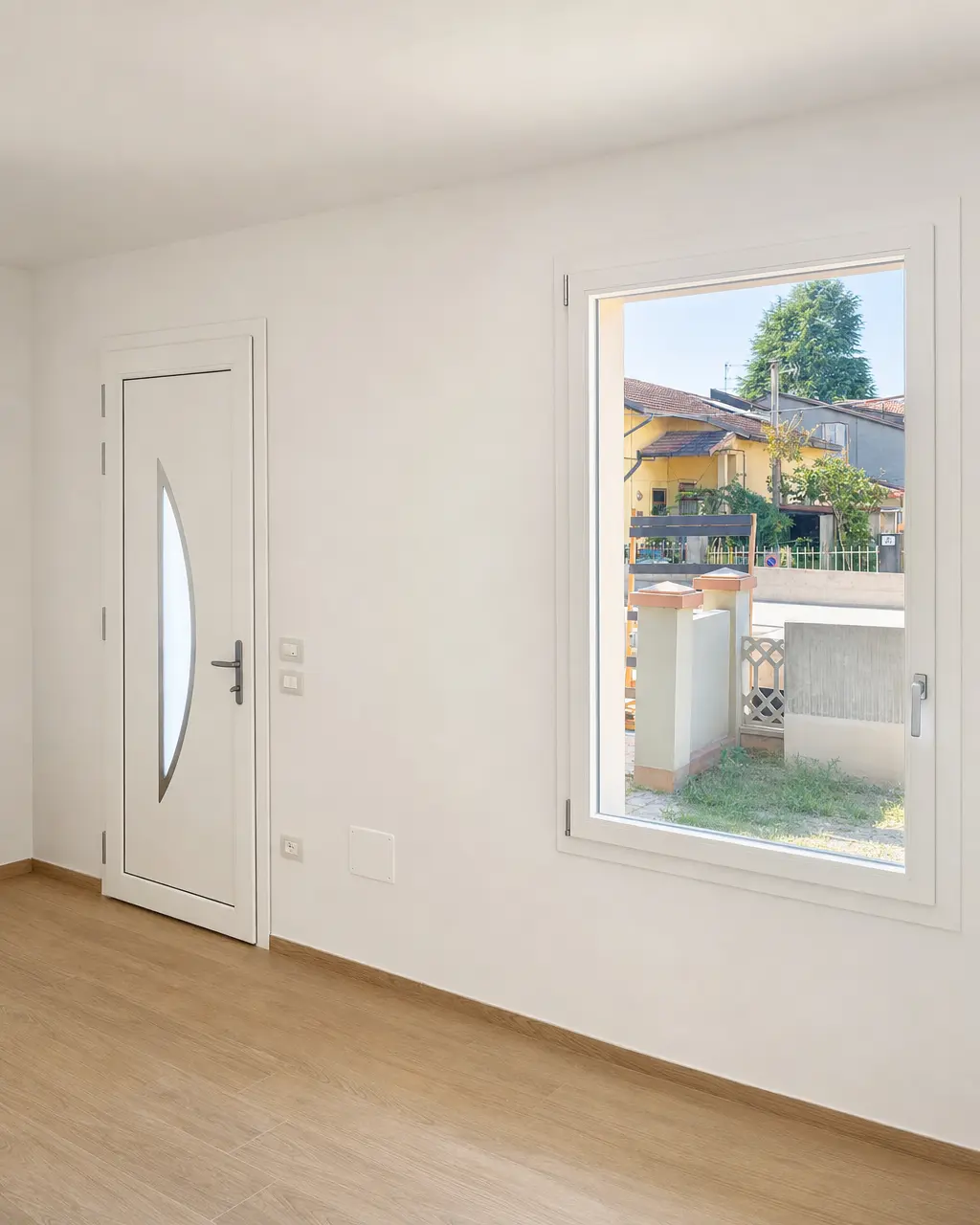 Portoncino d'ingresso e finestra in PVC bianco in una stanza appena finita