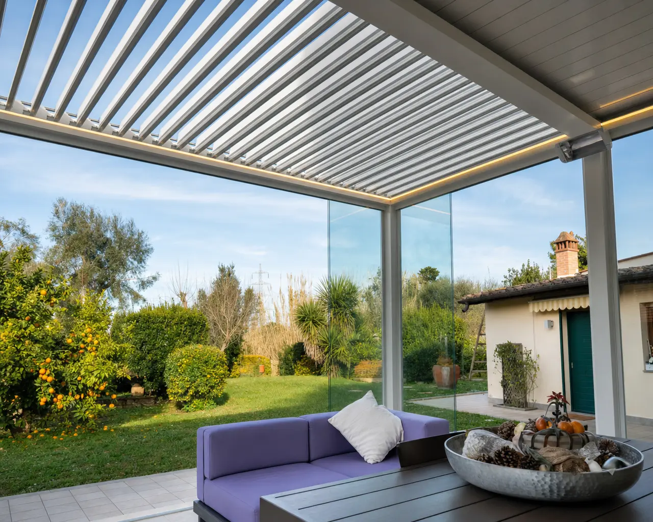 Pergola bioclimatica con lamelle orientabili e vetrate scorrevoli vista sul giardino